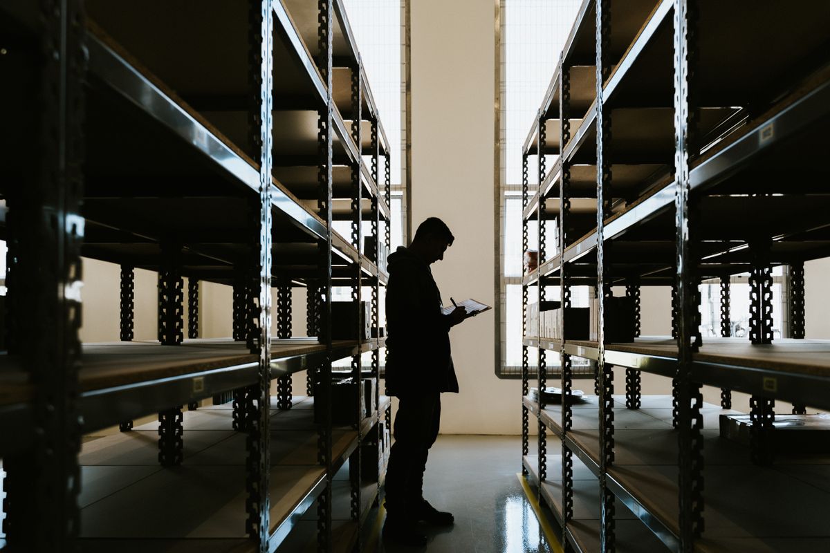Warehouse supervisor checking inventory with a clipboard