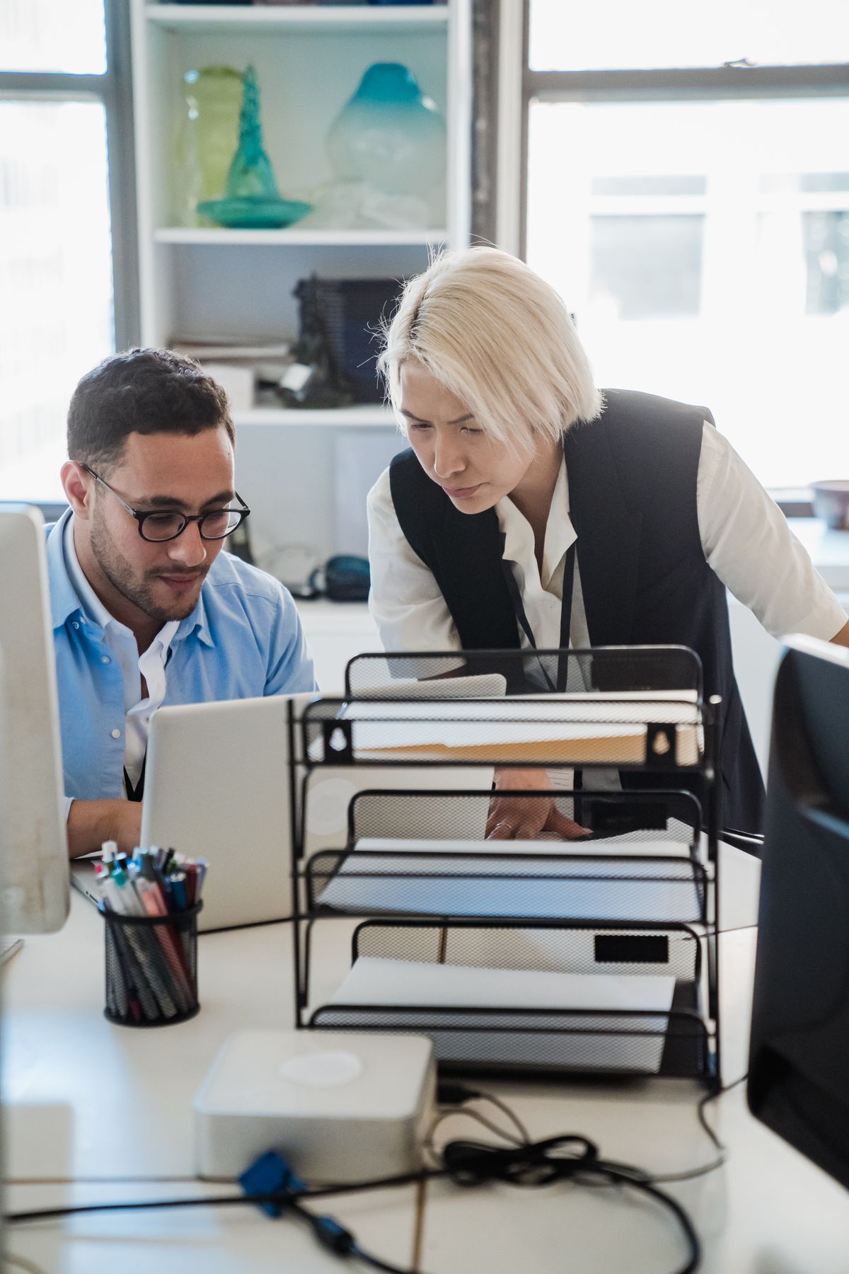 IT professionals collaborating at a workstation in a bright office